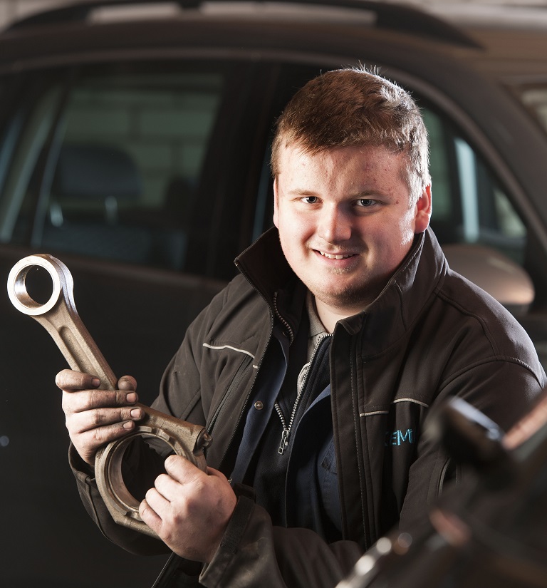 Hendrik van der Veen met een drijfstang in de werkplaats van Autobedrijf Ekema